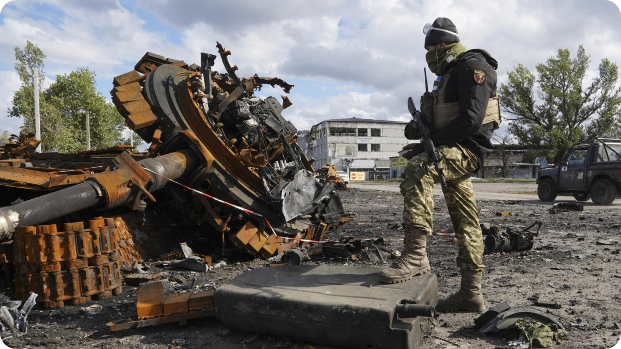 Ukrainian soldier stands by burnt russian tank